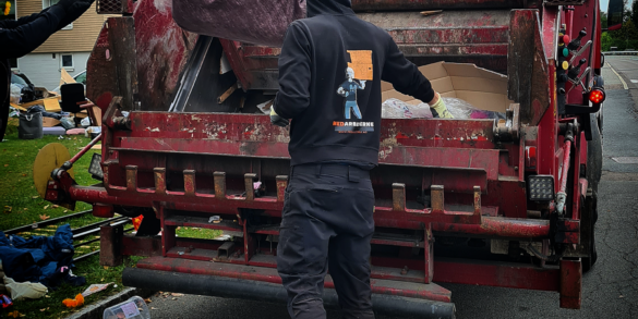 Medarbeider som kaster avfall i komprimatorbil